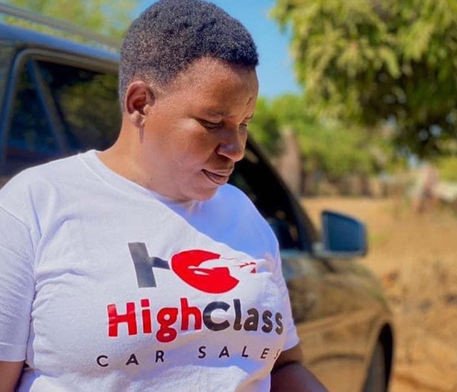 A member of the team in a branded shirt beside a vehicle on the forecourt